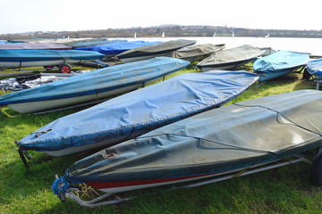 Row of sailing boats stored next to the lake