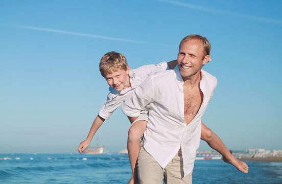 Father with son play together on the sea side