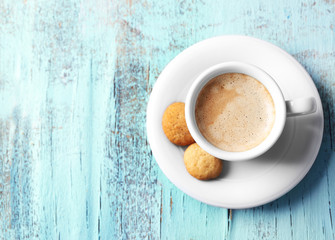 Cup of coffee on color wooden background