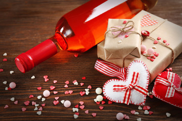 Red wine bottle and gift box on wooden background