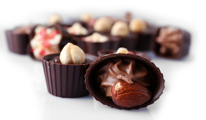 Delicious chocolate candies on white background, close up