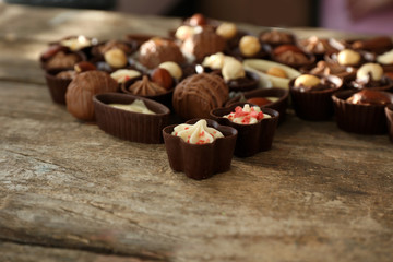Delicious chocolate candies on wooden background, close up