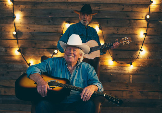 Two Smiling Senior Country And Western Musicians Sitting On Chai