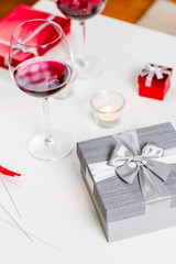 Table with glass  of wine and gifts
