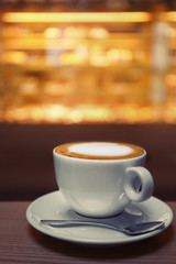 Cup of coffee on the table in the cafe, close up