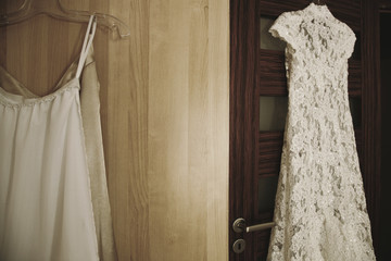 Suknia ślubna wisząca na drzwiach.