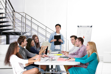 Young Asian man making a presentation at the office meeting