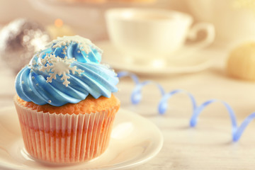 Tasty blue cupcake on plate with decorations, closeup