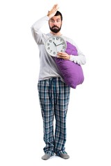 Man in pajamas holding clock