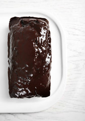 Chocolate cake with icing on white table