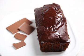 Chocolate cake with icing on white table