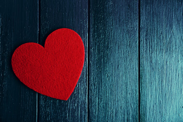 Red felt heart on purple wooden background