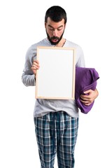 Man in pajamas holding an empty placard