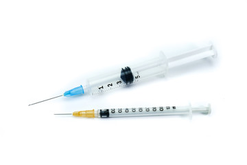 Two medical syringes, one big syringe with blue neddle and one small syringe with orange neddle, isolated on white background