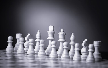 Chess pieces and game board on light green background