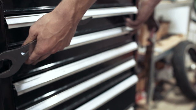 Mechanic is taking tool from tool box, pan, close up