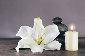 Fototapeta na wymiar Spa still life with beautiful flower and candlelight on grey background