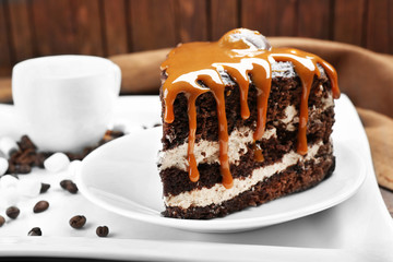Piece of chocolate cake with caramel in white plate closeup