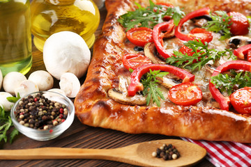 Freshly homemade pizza on wooden table closeup