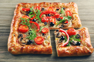 Freshly homemade pizza on wooden background