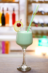 Glass of cocktail on bar background