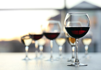 Glasses of wine on light blurred background