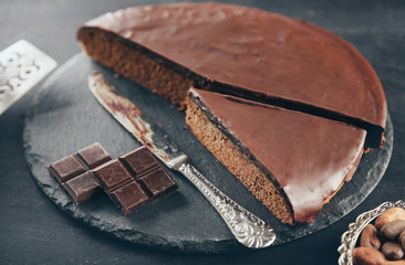 Sliced chocolate frosting cake on black table