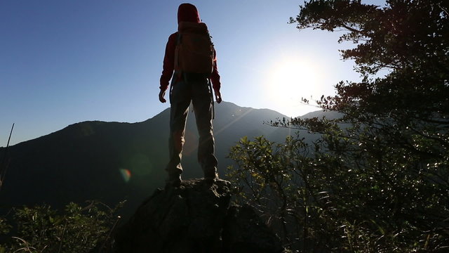 successful woman hiker open arms on sunrise mountain peak