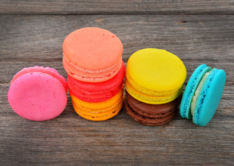 close up of colorful macarons on wooden background