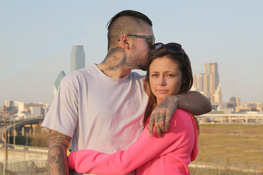 Young Couple embracing against Dallas Texas skyline