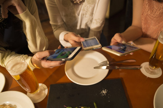 Three women have seen the smartphone during a meal