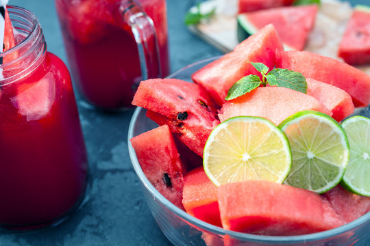 Watermelon slices with lime and smoothie on black table
