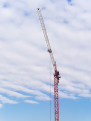 Tower crane on cloudy sky background
