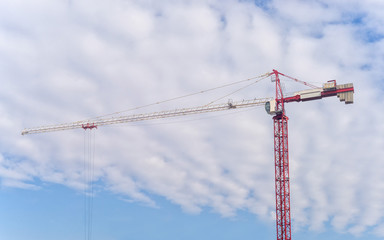 Tower crane on cloudy sky background
