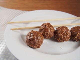 Chocolate balls with almond and peanuts on white dish