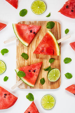 Watermelon slices on wooden stick with lime on white background