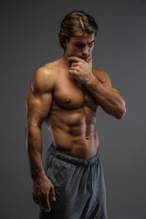 Fototapeta na wymiar Muscular guy isolated on a grey background.