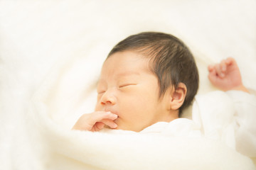 タオルに包まれて眠る新生児
