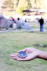 Female traveler holding a compass on nature