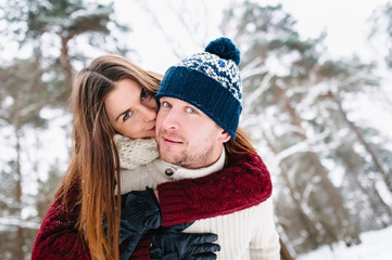 young attractive couple enjoying walk together in winter forest