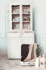 Beautiful vintage white suitcase lies open on the floor in the room