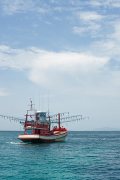 Red Fishing vessel moving at low speed