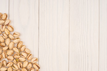 Roasted pistachio nuts on natural wooden table background, healt