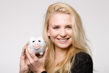 Hübsches fröhliches Mädchen mit Sparschwein