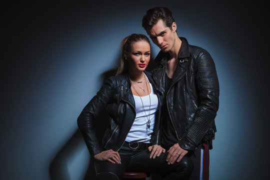 the man is posing looking at the camera and touching her leg whi