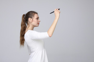 young woman with pen on grey background