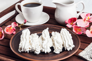 White marshmallow on a plate and coffee