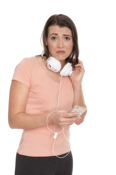 Junge Frau mit Kopfhörer und Handy schaut skeptisch 
