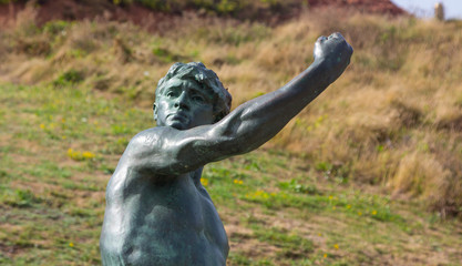 Old bronze statue of a young Greek