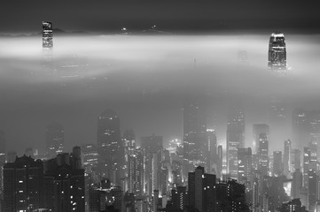 Misty night view of Victoria harbor in Hong Kong city